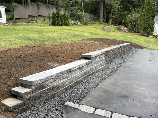 Retaining Wall Along Driveway - MAC Excavation & Landscape Block retaining wall with cap stones along driveway by MAC Excavation & Landscape in South Shore MA