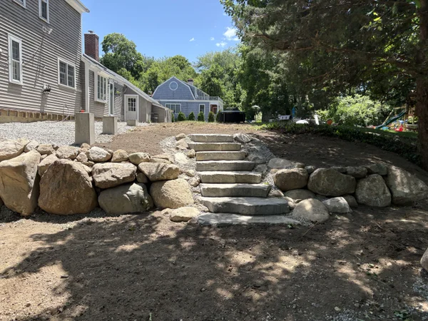 Stone Landscape - MAC Excavation & Landscape Boulder retaining wall with stone steps installation by MAC Excavation & Landscape in South Shore MA