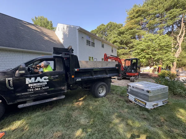 Hardscape Construction — East Bridgewater, MA MAC Excavation & Landscape dump truck and mini excavator staged for hardscape construction at an East Bridgewater, MA home